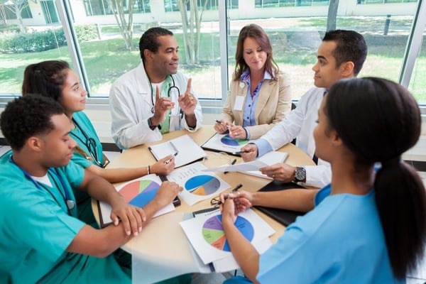 Hospital executive discuss revenue cycle management strategy with hospital staff